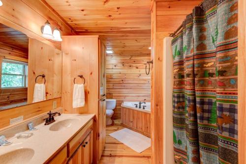 La salle de bains est pourvue d'une cabine en rondins, d'un lavabo et d'une baignoire. dans l'établissement Chestnut Lodge, à Boone