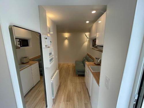 a small kitchen with white cabinets and a refrigerator at Cozy studio ideal for a stay in Bagneux in Bagneux