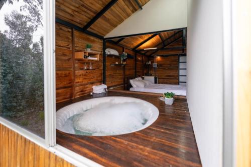 a large tub in a room with a bedroom at Costa Azul Refugio Frailejon in Tibasosa