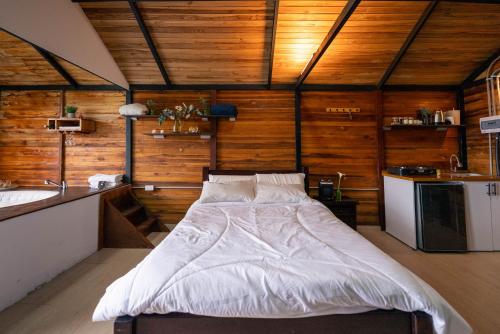 a bedroom with a large bed in a room with wooden walls at Costa Azul Refugio Frailejon in Tibasosa