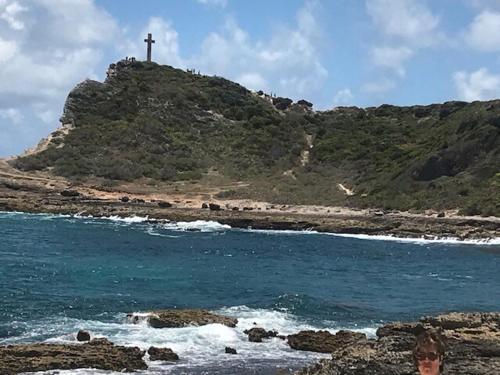 a cross on top of a hill next to the ocean at Bright F2 Apartment in Saint-Claude