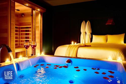 una habitación con una cama y una bañera con un dormitorio en LiFE VOYAGE RESIDENCE & SPA - Strasbourg's City Center Luxury Experience, en Estrasburgo