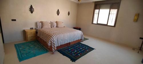 a bedroom with a bed with two pillows on it at Hôtel Restaurant Dar Al Madina in Tinerhir