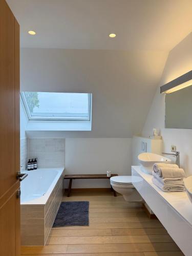 a bathroom with a tub and a toilet and a sink at Biervlietmolen Vakantiewoning in Diksmuide