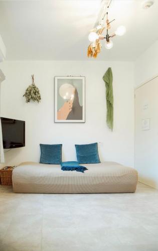 a bed in a white room with blue pillows at 伊勢神宮内宮前-民泊宿i s e s h i m a -201 in Ise
