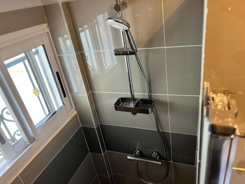 a shower head in a bathroom with a window at Villa le chant des Alizés 