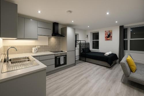 a kitchen and a living room with a couch at LT 0 - Studio Apartment in Leicester