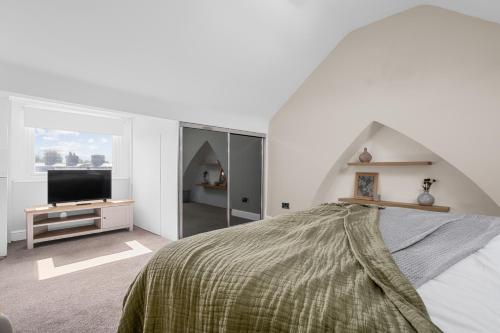 a white bedroom with a bed and a tv at Three Bedroom House by Brookland Stays Serviced Accommodation Short Lets Manchester with Free WiFi in Manchester