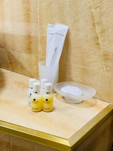 a counter with four bottles of essential oils and a plate at Bəy Hotel Baku in Baku