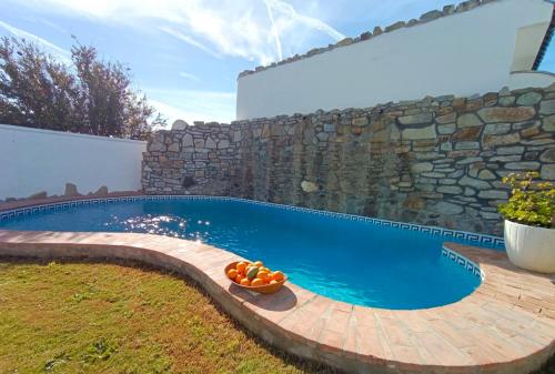 - une piscine dans une cour dotée d'un mur en pierre dans l'établissement Casa Monte, à El Palmar