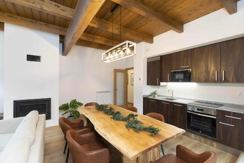 a kitchen with a wooden table and chairs at Sueños del Garmo by BeValle in Panticosa