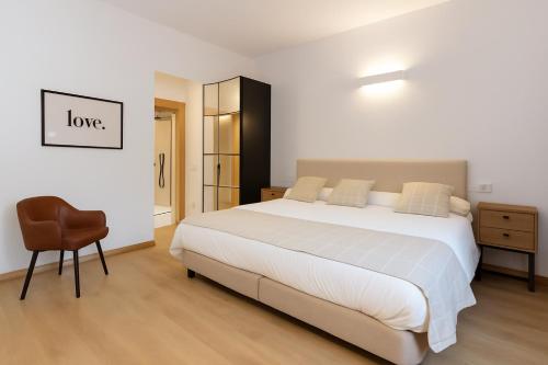 a bedroom with a large white bed and a chair at Sueños del Garmo by BeValle in Panticosa