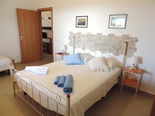 a bedroom with a large white bed with blue pillows at Case Maiolica in Piano Conte
