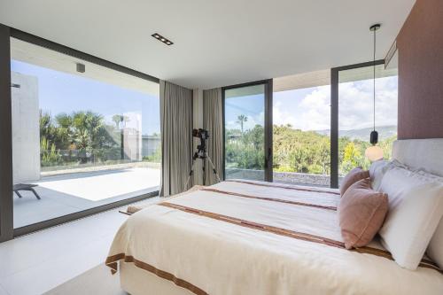 a bedroom with a large bed and a large window at Troia Design Villa by CadenzaLux in Troia