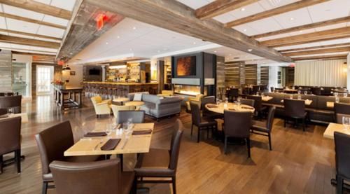 a restaurant with tables and chairs and a bar at Hanover Inn Dartmouth in Hanover