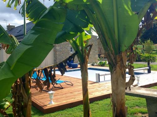 a wooden deck next to a swimming pool at gîte en campagne Lamégritnière in Mégrit