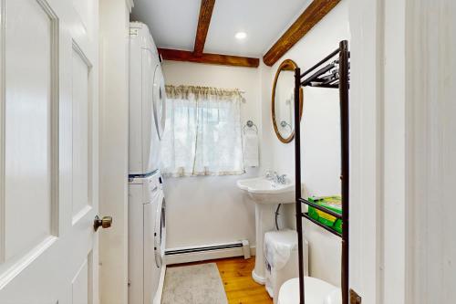 Un baño blanco con lavabo e inodoro. en Peaceful Cape Escape, en Marstons Mills