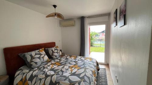 a bedroom with a bed and a window at Songe Péi - T2 - Est Réunion - Piscine & Parking in Saint-André