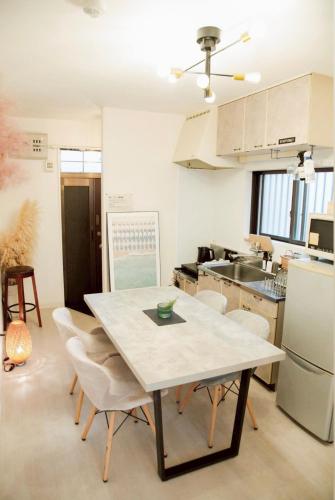 a kitchen with a table and chairs in a room at 伊勢神宮内宮前-民泊宿i s e s h i m a -201 in Ise