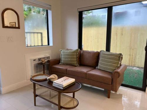 a living room with a brown couch and a table at Chic Modern Studio with Queen Bed in Fort Lauderdale