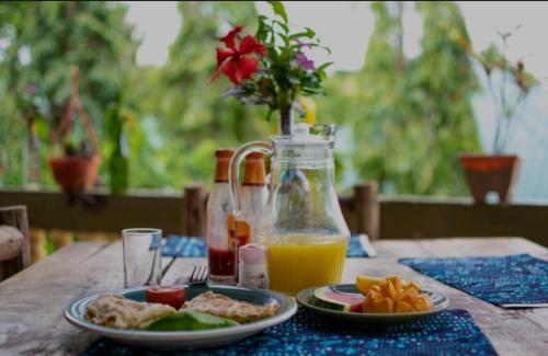 a table with a plate of food and a bottle of orange juice at Mai Kilimanjaro Home Stay in Marangu