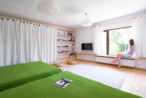 a woman sitting on a window sill in a bedroom at Garden House in Timişoara