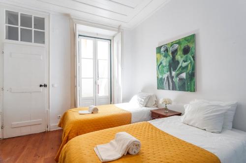 two beds in a room with white walls at Camões - Bairro Alto - by The Portuguese Story in Lisbon