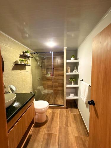 a bathroom with a shower and a toilet and a sink at Hermosa casa en el centro de Filandia, Quindío in Filandia