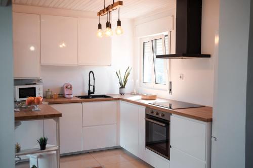 a white kitchen with white cabinets and a window at Casa da Estação, vista rio Tâmega e Senhora da Graça in Veade