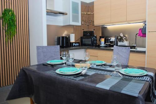 プラ・ド・モロ・ラ・プレストにあるAppartement Saintes Juste et Ruffine centre ancienの台所にテーブル(皿、グラス付)