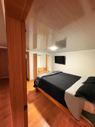 a bedroom with a bed and a flat screen tv at Hermosa casa en el centro de Filandia, Quindío in Filandia