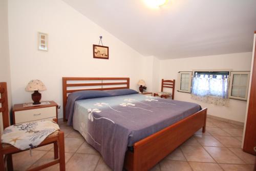 a bedroom with a bed and two chairs and a window at Lido di Noto Villa Cocus Apartment Vista Mare in Noto Marina