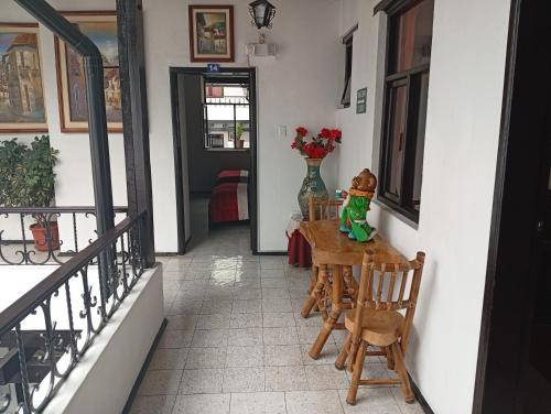 una stanza con un tavolo con un vaso di fiori di Hostal Flores a Quito
