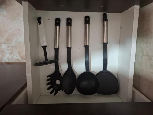 four utensils are hanging in a white box at Frutos de la Tierra in Comodoro Rivadavia