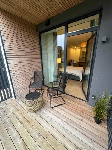 a deck with two chairs and a bed in a bedroom at MuunLiving in Ķesterciems