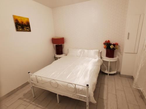 a white bed in a room with two night stands at Le Refuge Nature à 20 min de Paris et d'Orly via RER Juvisy in Draveil