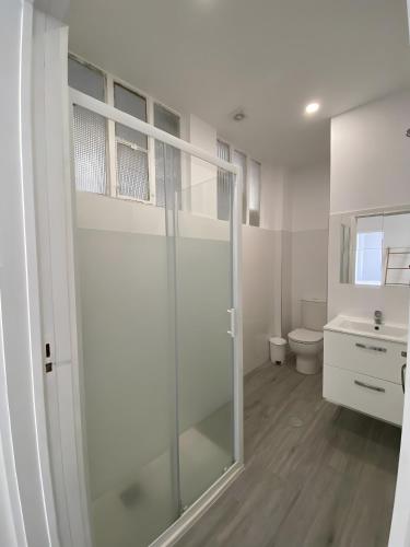 a bathroom with a glass shower and a toilet at T4 Furadouro with sea view in Furadouro