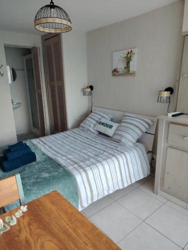 a bedroom with a bed and a table in it at Chez Pam et David in Saint-Maixent-lʼÉcole