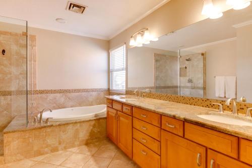 Un baño con dos lavabos, una bañera y una ducha. en Lakefront Living! Huge Phoenix Home with Dock, Pool, en Phoenix