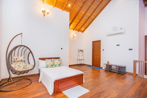 a living room with a bed and a chair at Clara Villas Amithirigala in Avissawella