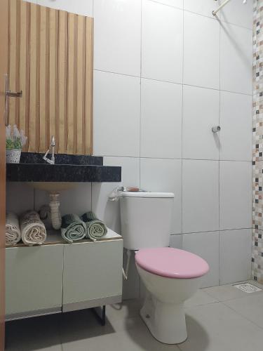 Un baño con un inodoro rosa y un lavabo. en Casa Borges, en Aparecida de Goiania