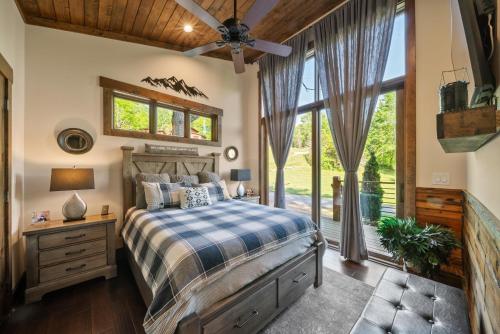Un dormitorio con una cama y una ventana grande. en Red Wolf Chalet at Eagles Nest, en Banner Elk