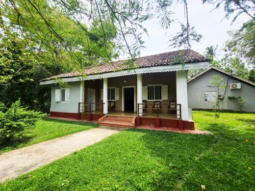 una pequeña casa blanca con un patio verde en CalmDown, en Ahangama