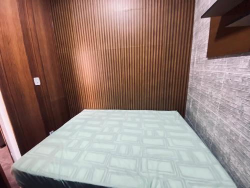 a small bed in a room with a wooden wall at Charming Bahia House in Pelourinho in Salvador