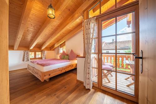 a bedroom with a bed and a large window at Schoberhof in Samerberg