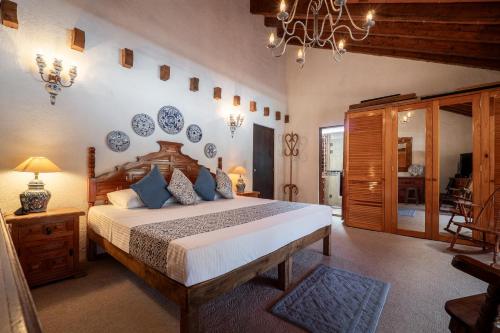 a bedroom with a large bed with blue plates on the wall at Casa Mexicana con Alberca Techada y Jardín in Tequisquiapan