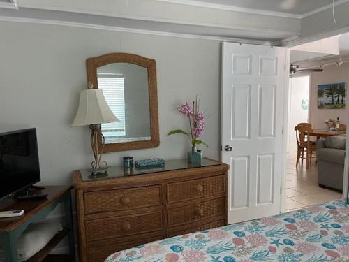 a bedroom with a bed and a dresser with a mirror at Gulf Front Cottages in Englewood
