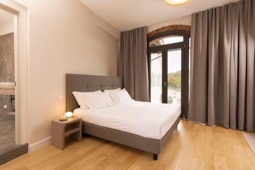 a bedroom with a bed and a large window at Vinea Relais in Dogliani