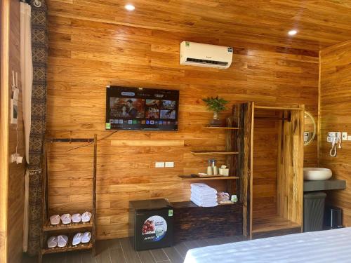 a room with a wooden wall with a bathroom at Mely Farm Mường Lò in Văn Chấn