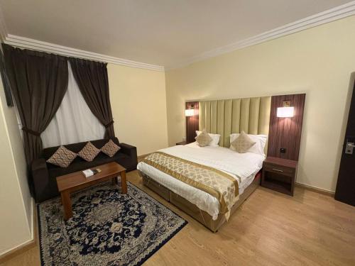 ein Schlafzimmer mit einem Bett, einem Tisch und einem Fenster in der Unterkunft لؤلؤة الثريا للشقق المخدومة فرع العقيق in Riad